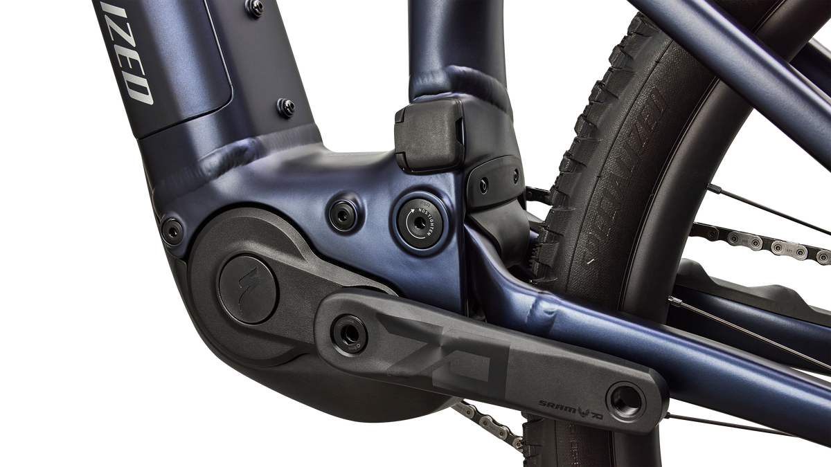 A close up view of the motor and crank of a blue Specialized Levo R Comp Alloy electric assist mountain bike.