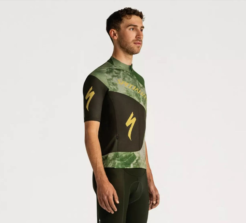 Right profile view of a man wearing a green and black Specialized Foundation short sleeve cycling jersey on a white background.