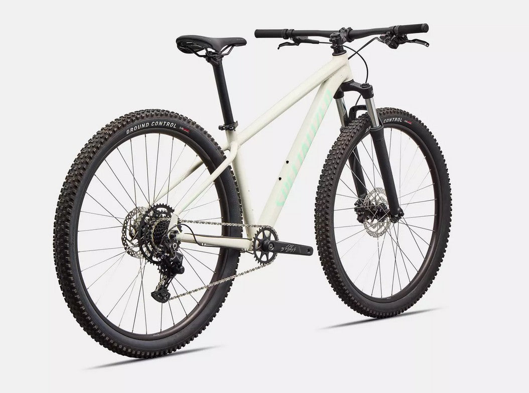 Back right angled view of white Specialized Rockhopper Sport mountain bike with black tires on a white background