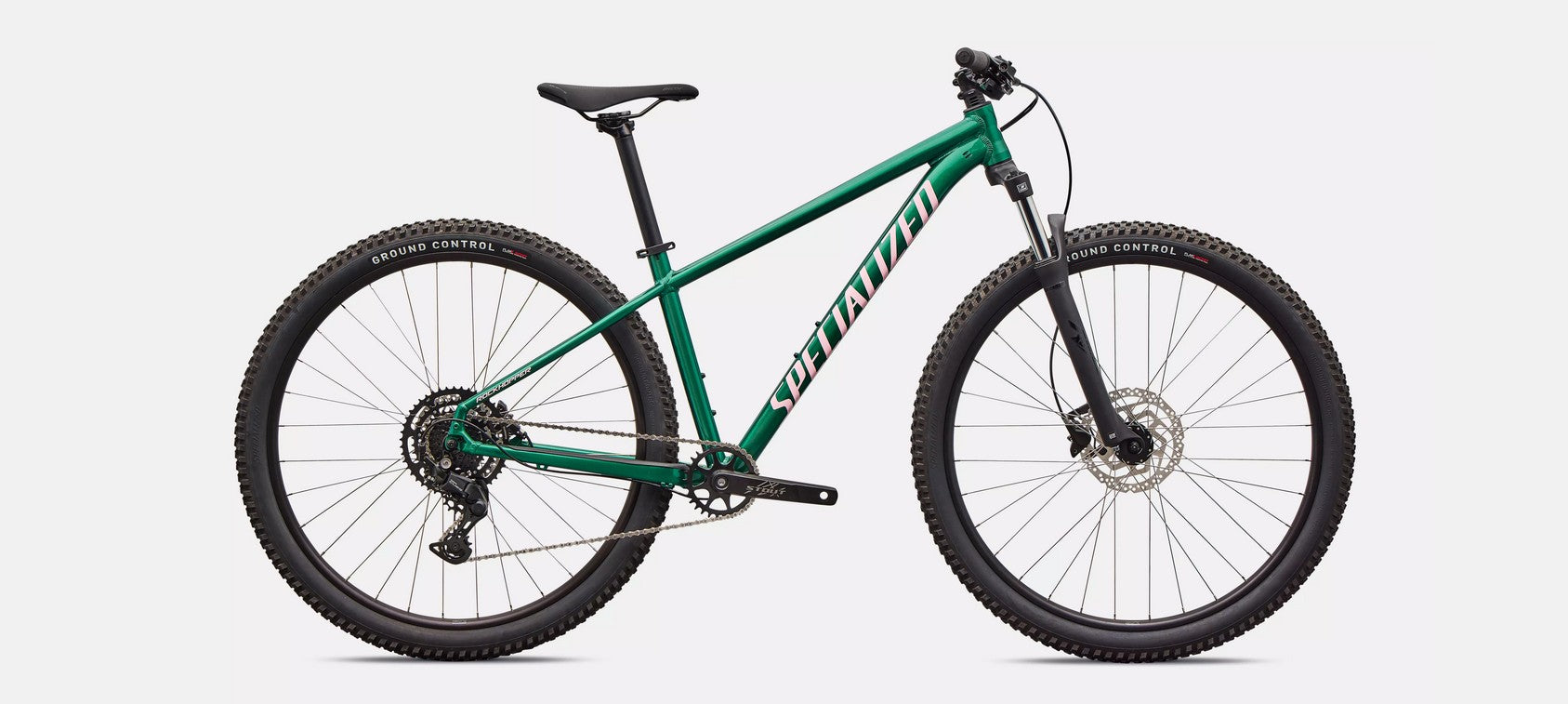 Right profile of green Specialized Rockhopper Sport mountain bike with light pink accents on a white background.