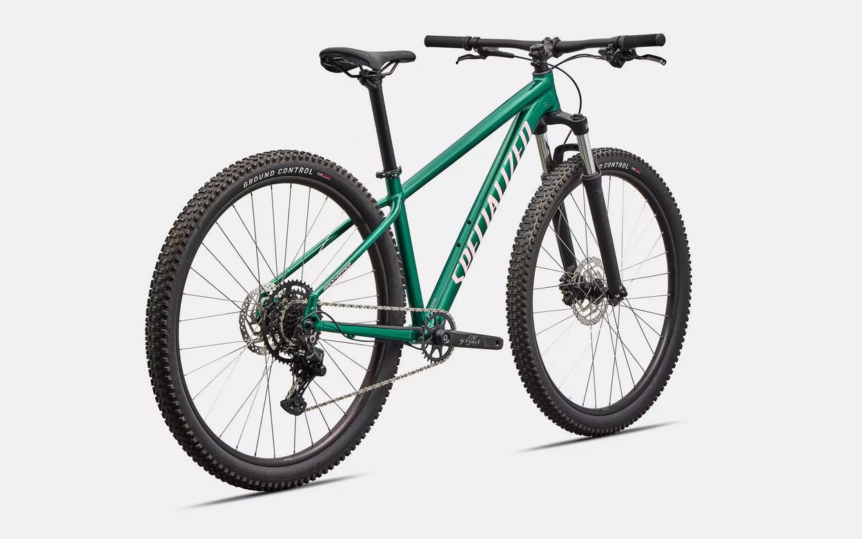 Rear right profile view of green Specialized Rockhopper Sport mountain bike with pink accents on a white background.