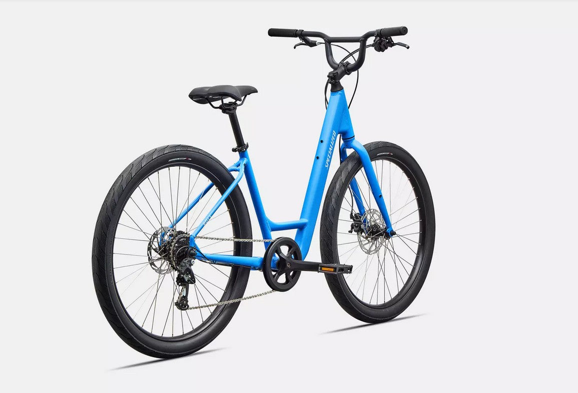Back right profile view of blue Specialized Roll bicycle with white lettering and black components on white background. 