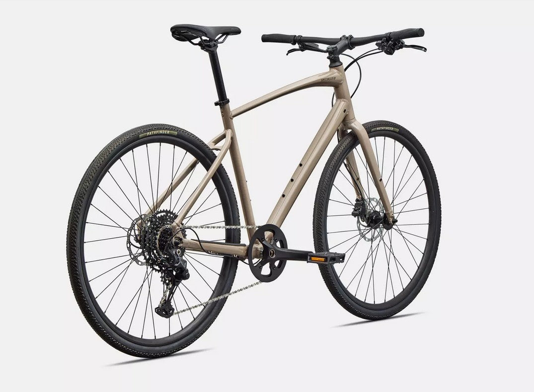 Back right profile of beige Specialized Sirrus bicycle with black components on a white background.