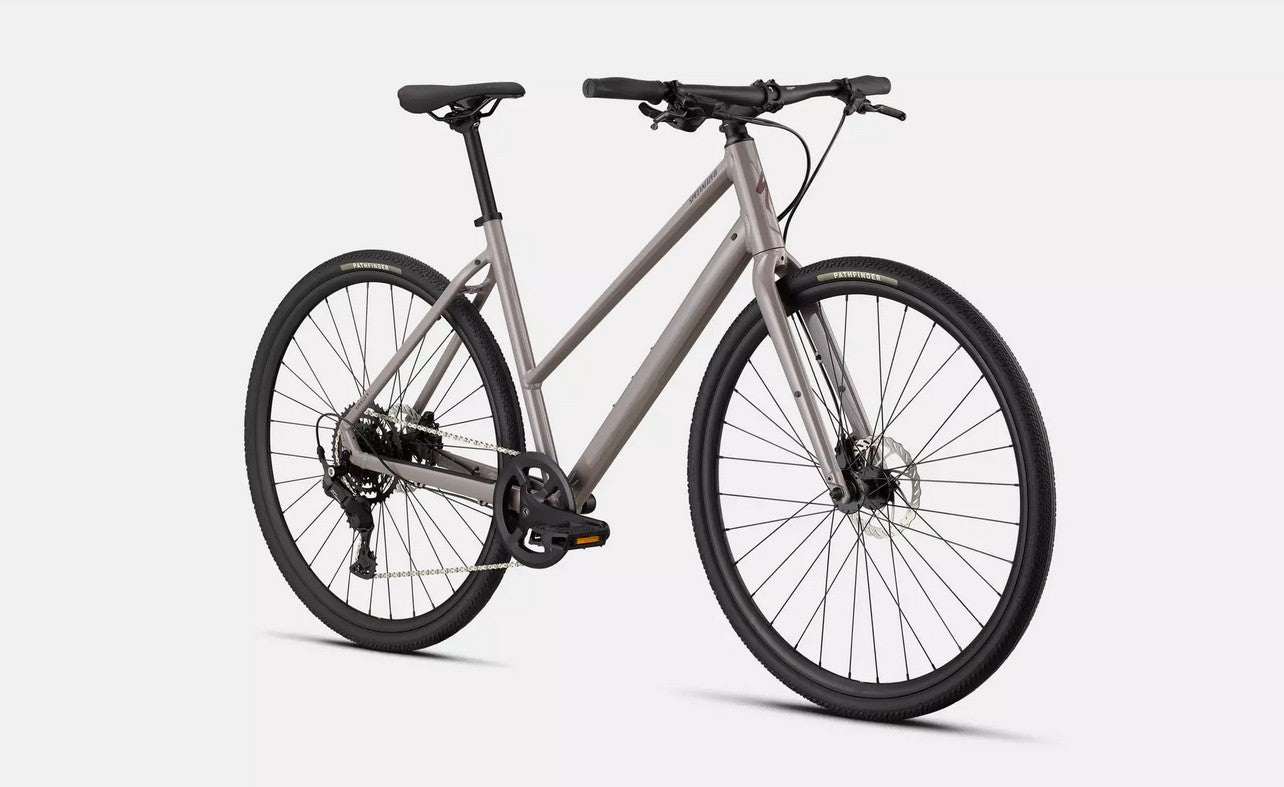 Front right angled profile view of a glass tan Specialized Sirrus bicycle with black components on a white background.