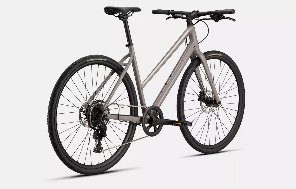 Back right angled profile view of a tan Specialized Sirrus X bicycle with black components on a white background. 