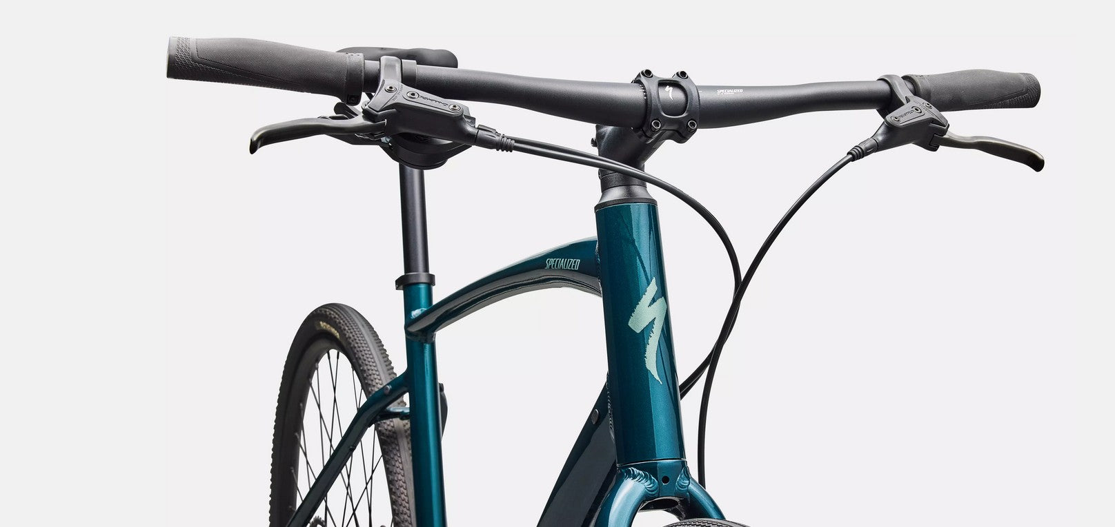 Close-up of a emerald green bicycle with black handlebars on a light gray background