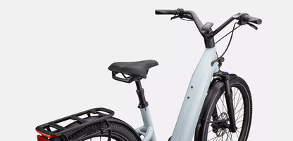 Light blue Specialized Turbo Como electric bike with a black seat and rear storage rack on a white background