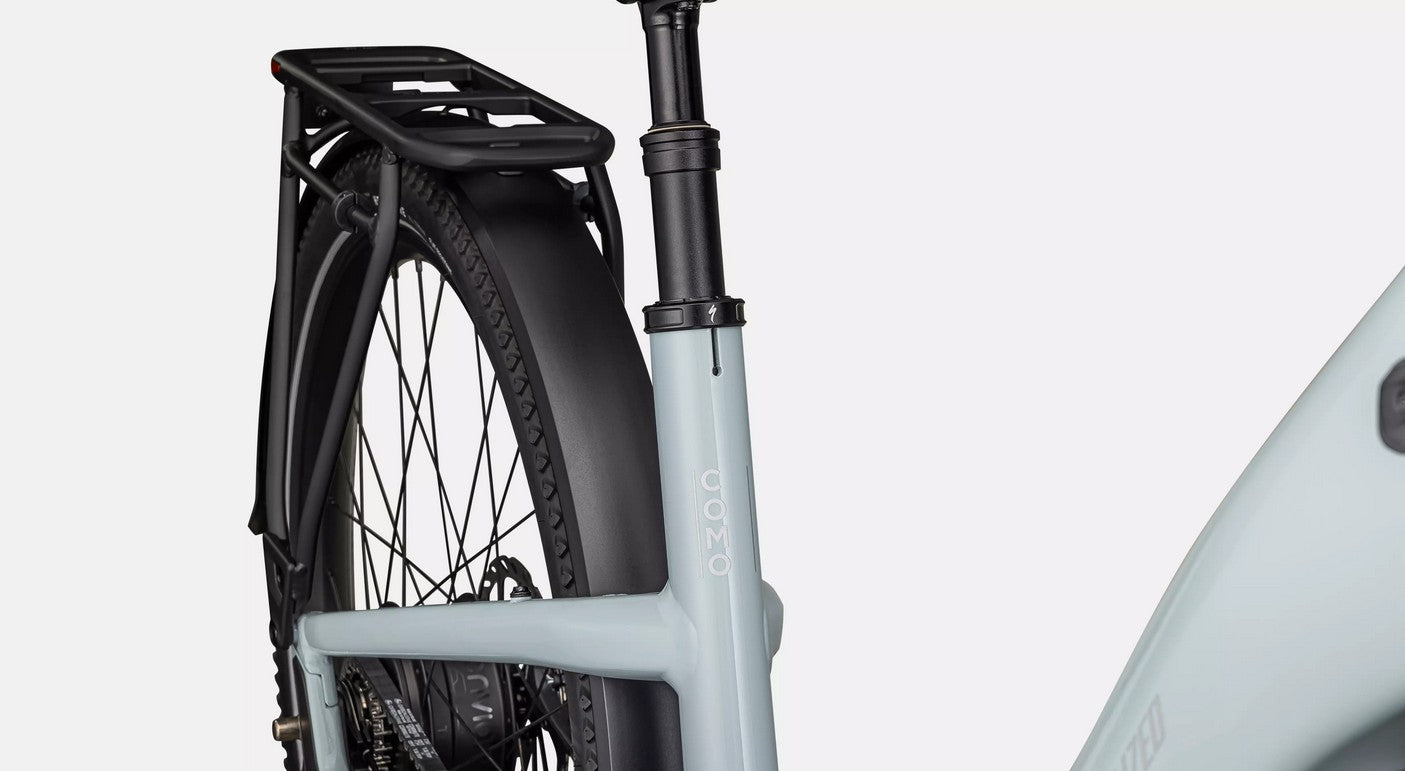 Close-up of a Specialized Turbo Como electric bicycle with a black rear rack on a white background