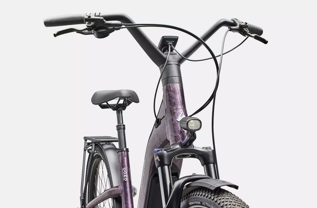 Close-up of a Specialized Turbo Como electric bicycle with a purple frame on a white background