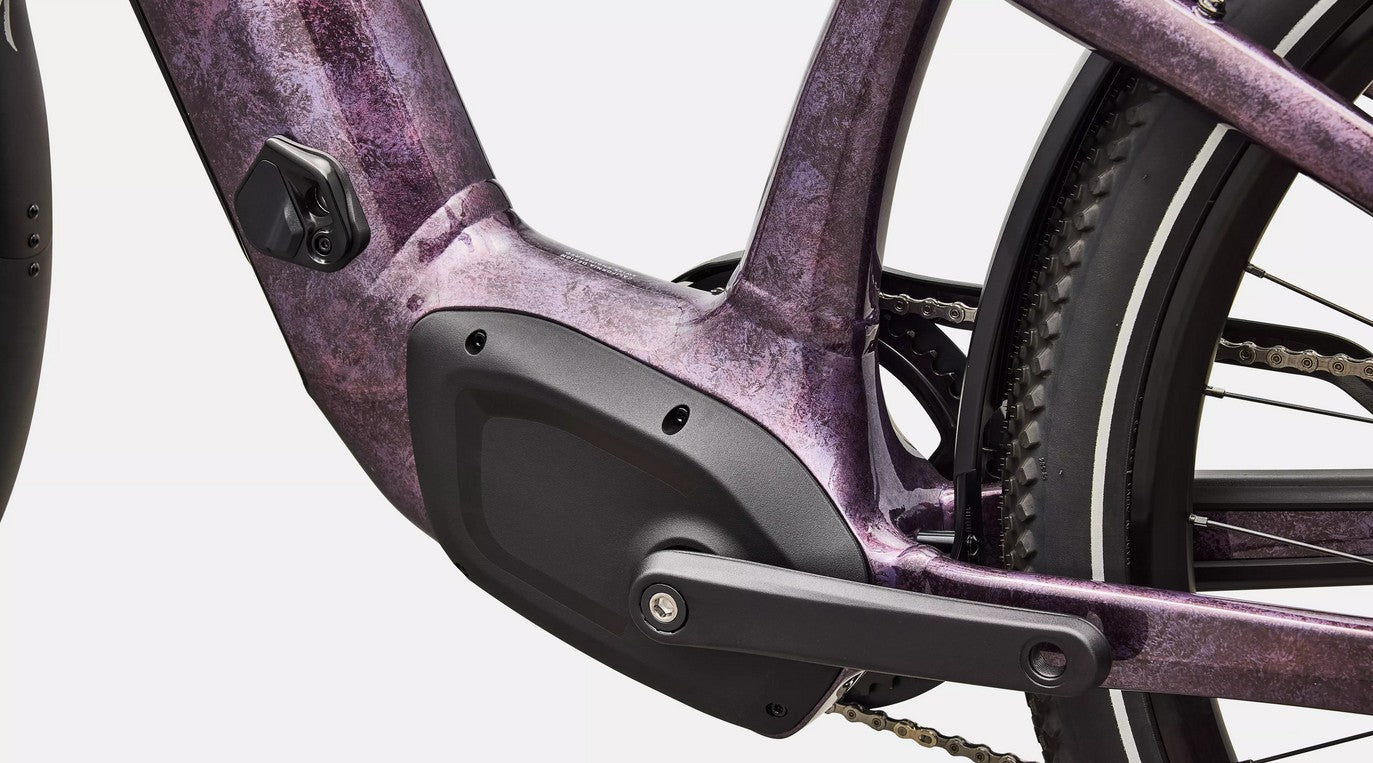 Close-up of a purple electric bicycle's mid-drive motor system.