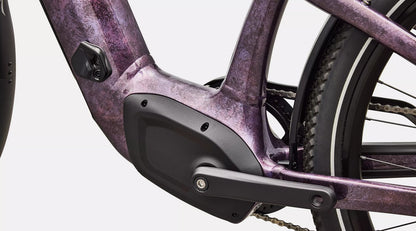 Close-up of a purple electric bicycle's mid-drive motor system.