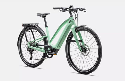 Front right angled profile view of a light green Specialized Vado electric bicycle with black components on a white background. 