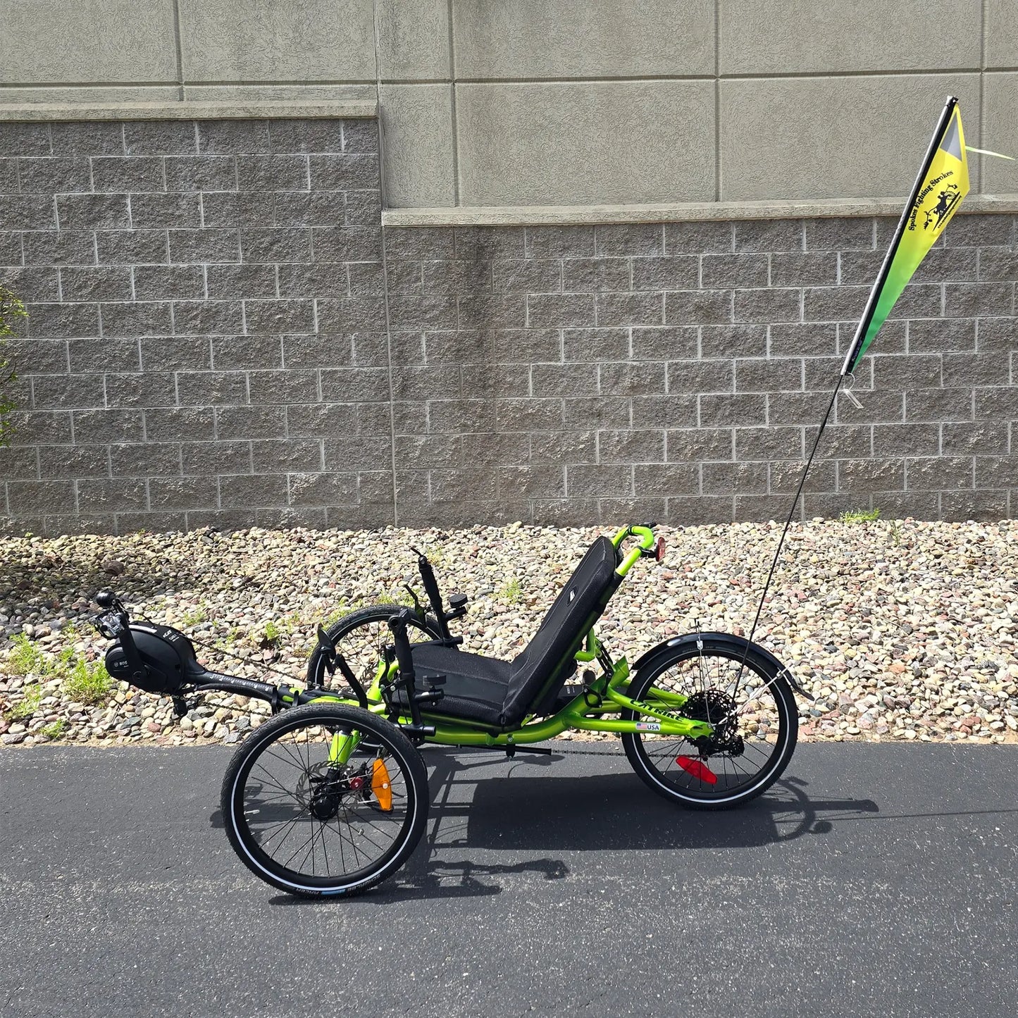 View of the Spokes Fighting Strokes Logo Flag without Handicapped Symbol  on a trike in an outdoor setting.