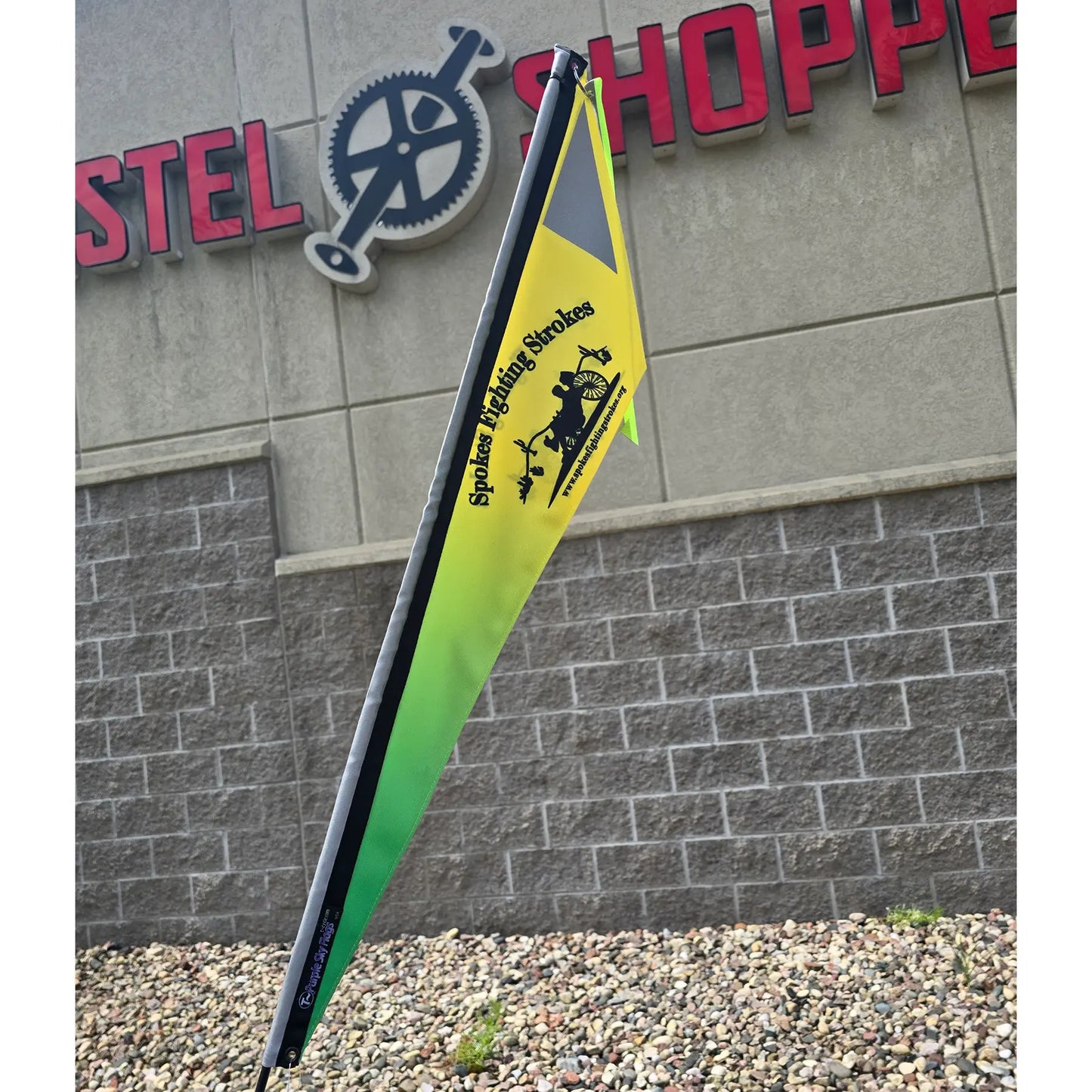 Closeup view of the Spokes Fighting Strokes Logo Flag without Handicapped Symbol in an outdoor setting.