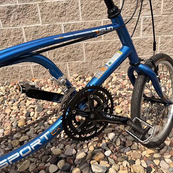 Closeup view of the frame and crankset on the Sun Seeker Used EZ-Sport CX 26-20 Lemans Blue Recumbent Bike in an outdoor setting.