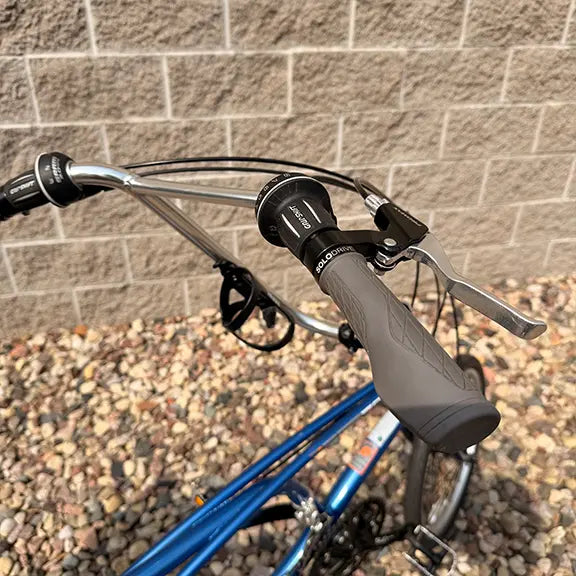 Closeup view of the brake lever and right shifter on the Sun Seeker Used EZ-Sport CX 26-20 Lemans Blue Recumbent Bike in an outdoor setting.