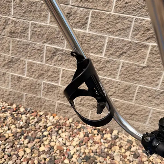 Closeup view of the bottle cage mounted on the handlebar on the Sun Seeker Used EZ-Sport CX 26-20 Lemans Blue Recumbent Bike in an outdoor setting.