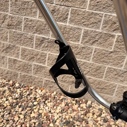 Closeup view of the bottle cage mounted on the handlebar on the Sun Seeker Used EZ-Sport CX 26-20 Lemans Blue Recumbent Bike in an outdoor setting.