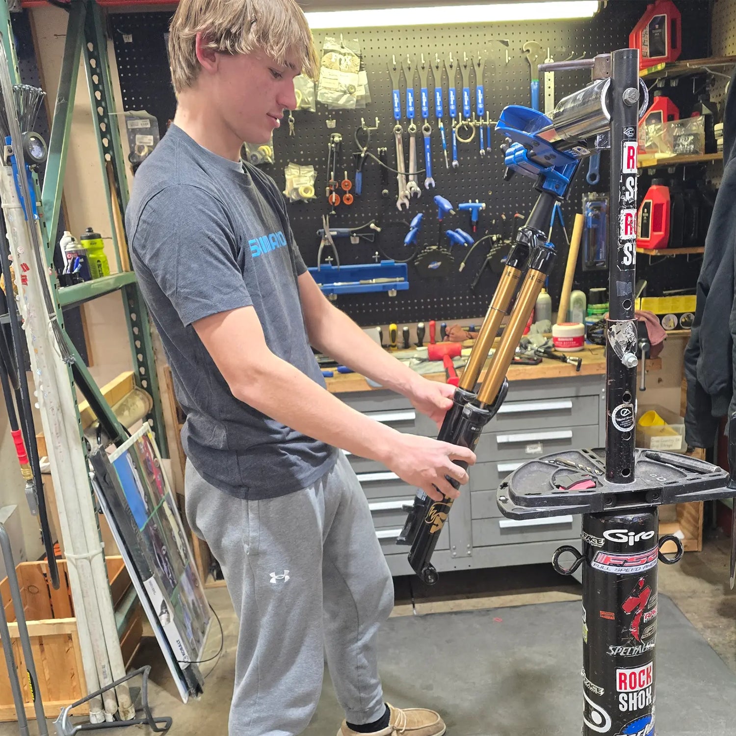 A bike mechanic services a suspension fork.