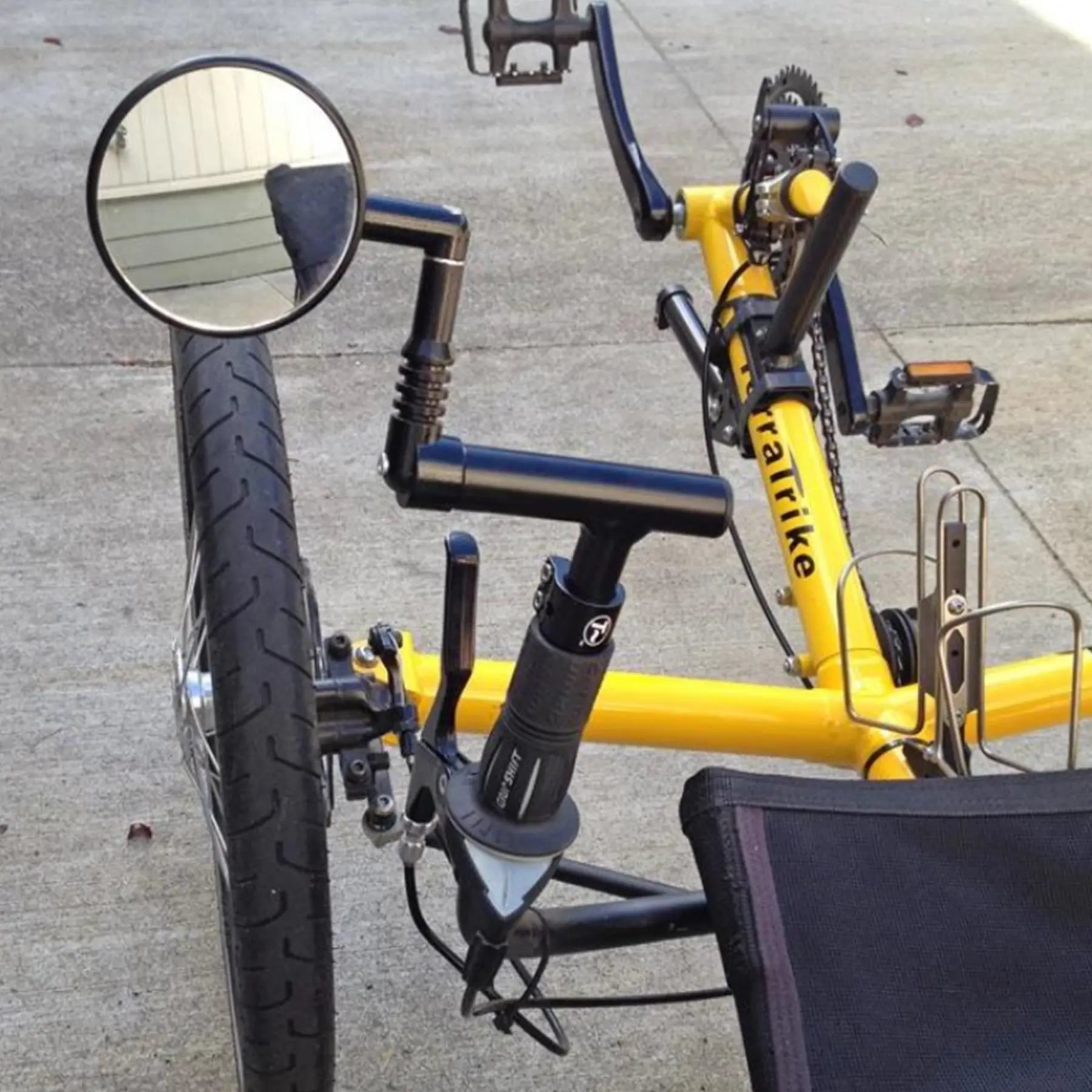 View of the T-Cycle Cockpit Mini T 3.75 inch without cable hole mounted on a recumbent trike handlebar with a mirror installed on it.