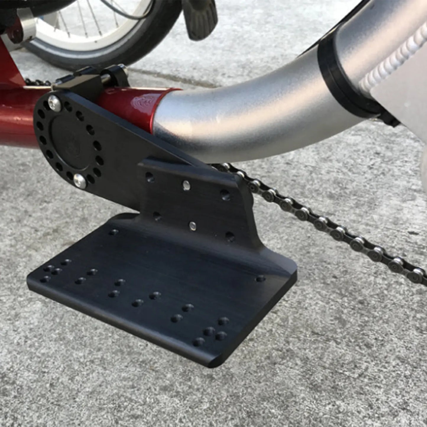 Closeup view of the T-Cycle Configurable Battery Mount mounted on an ICE Q trike against a grey background.