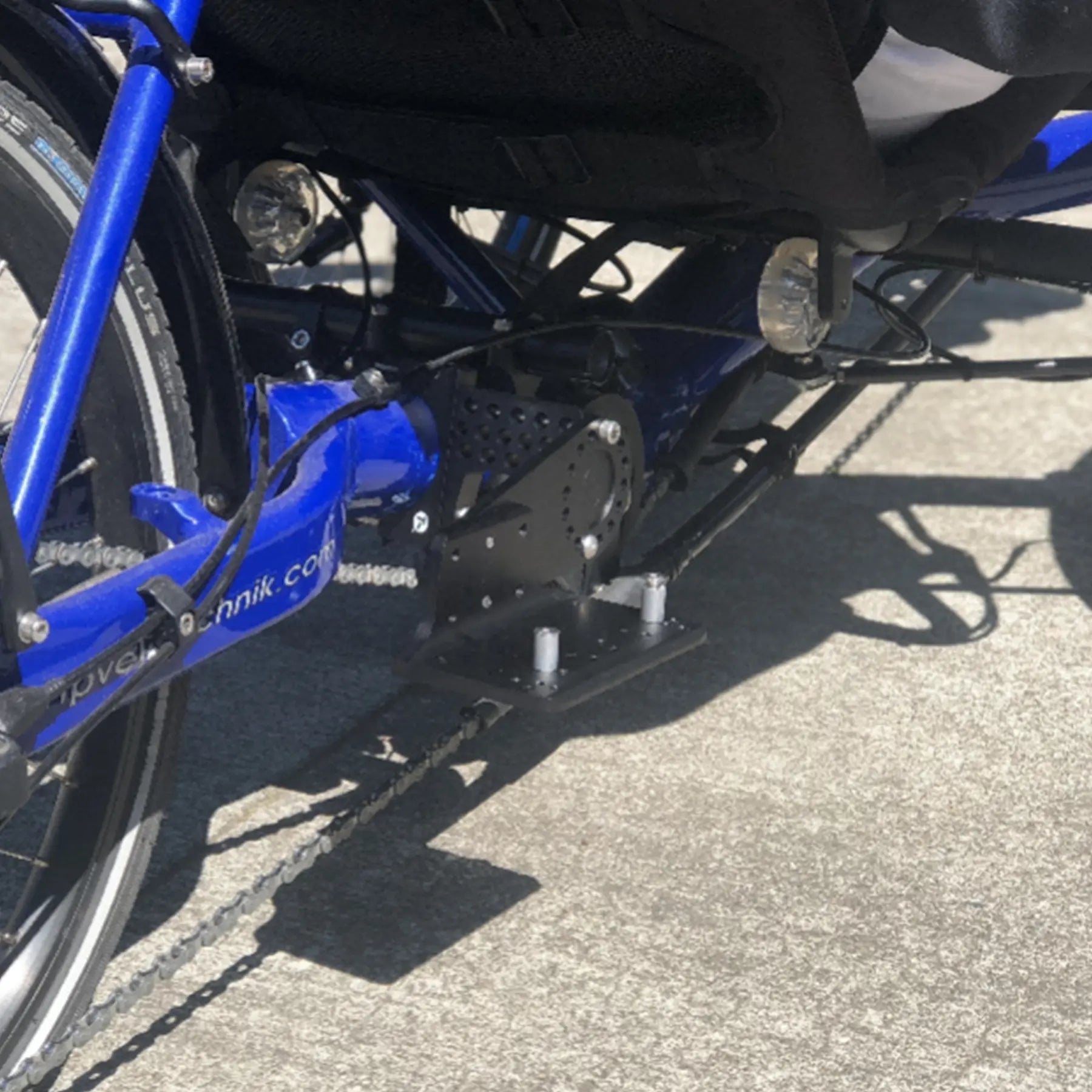 Closeup view of the T-Cycle Configurable Battery Mount mounted on an HP Velotechnik Gekko fx trike against a grey background.