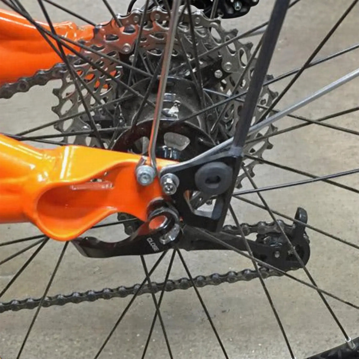 Closeup view of the T-Cycle Flag Grommet For Catrike Flag Mount in black mounted on a flag mount on an orange Catrike recumbent trike.