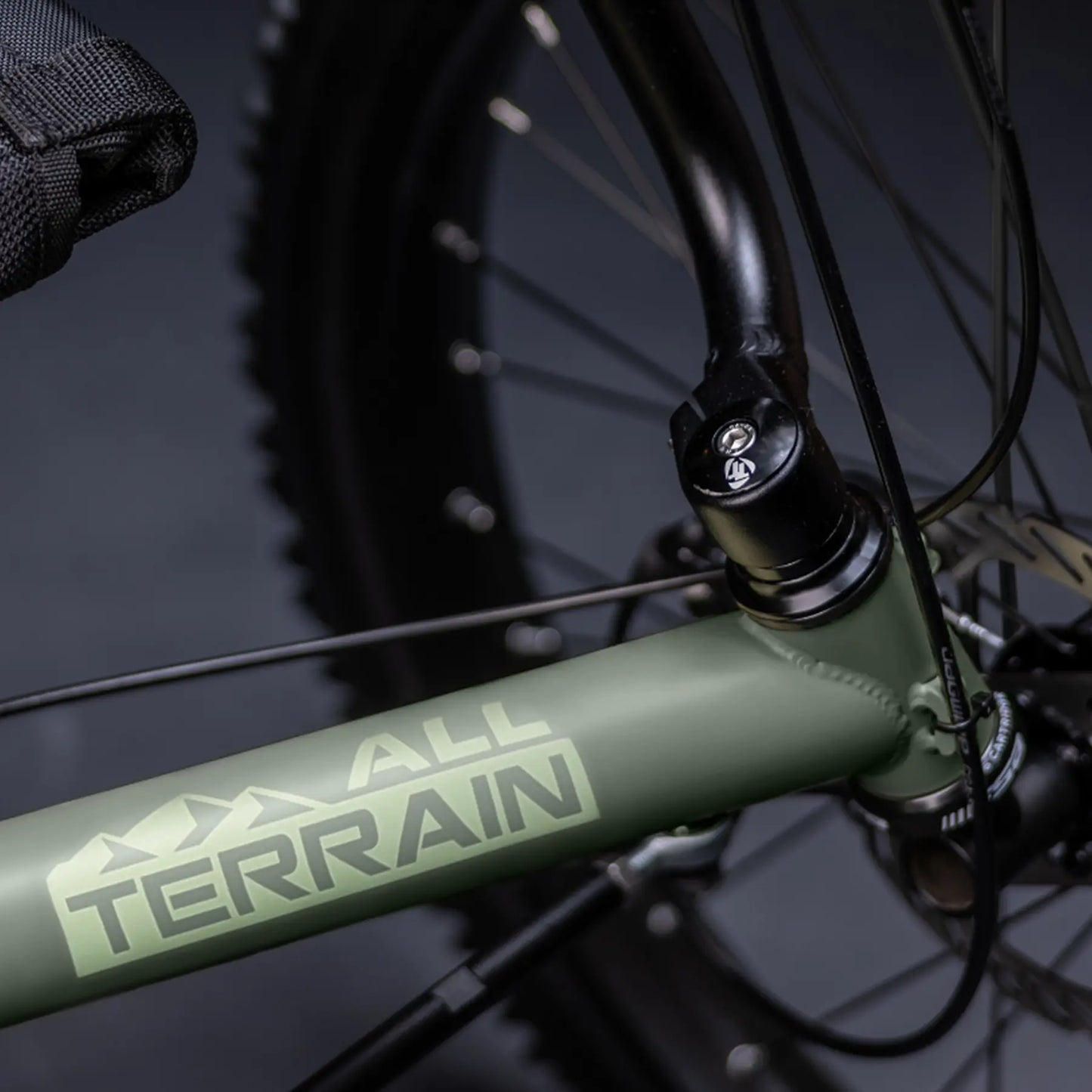 Closeup view of the All Terrain frame graphic on the the TerraTrike All Terrain Graphite Grey e-Plus Recumbent Trike against a grey background.