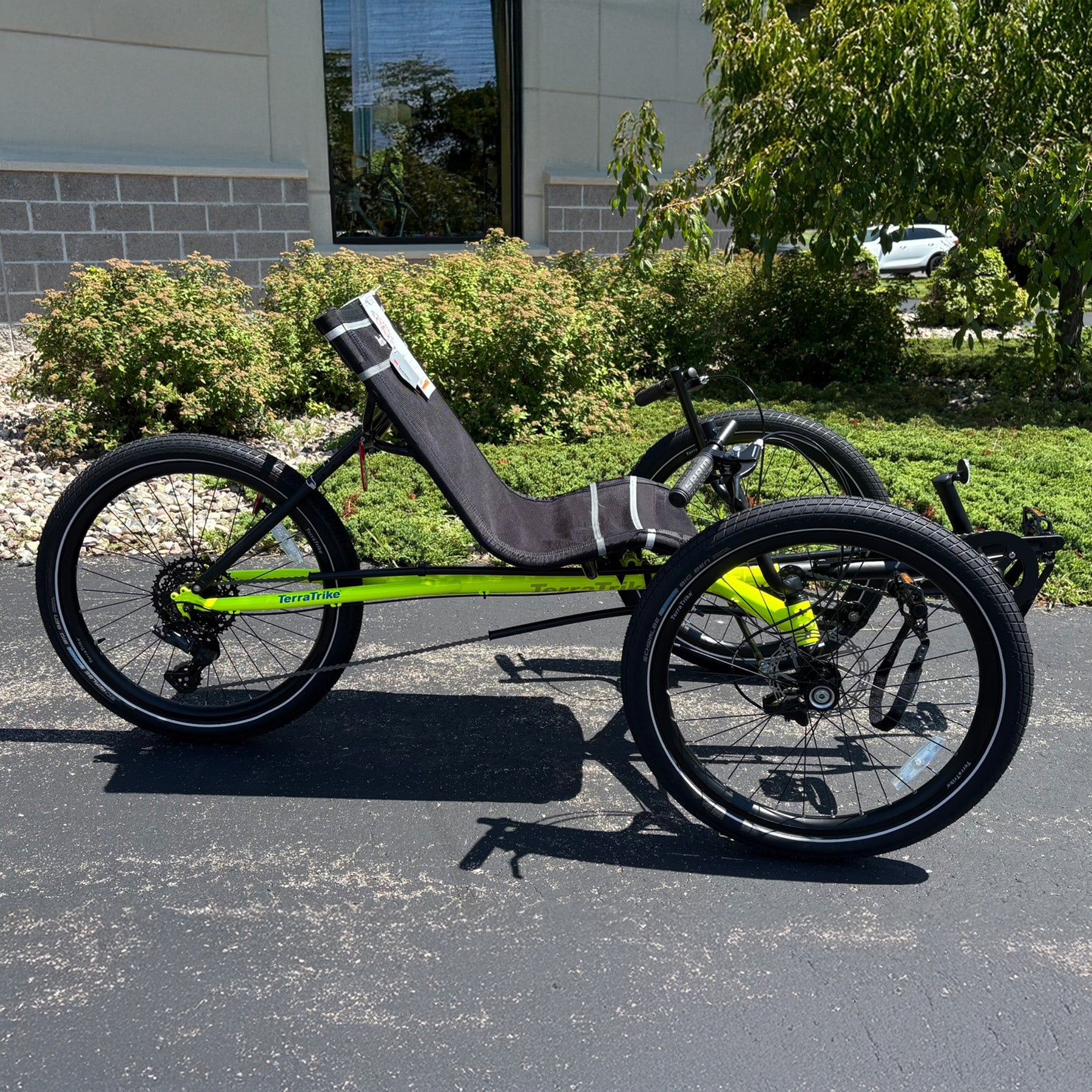 Side view of the Terratrike Demo Rambler Recumbent Trike in Salted Grass in an outdoor setting.