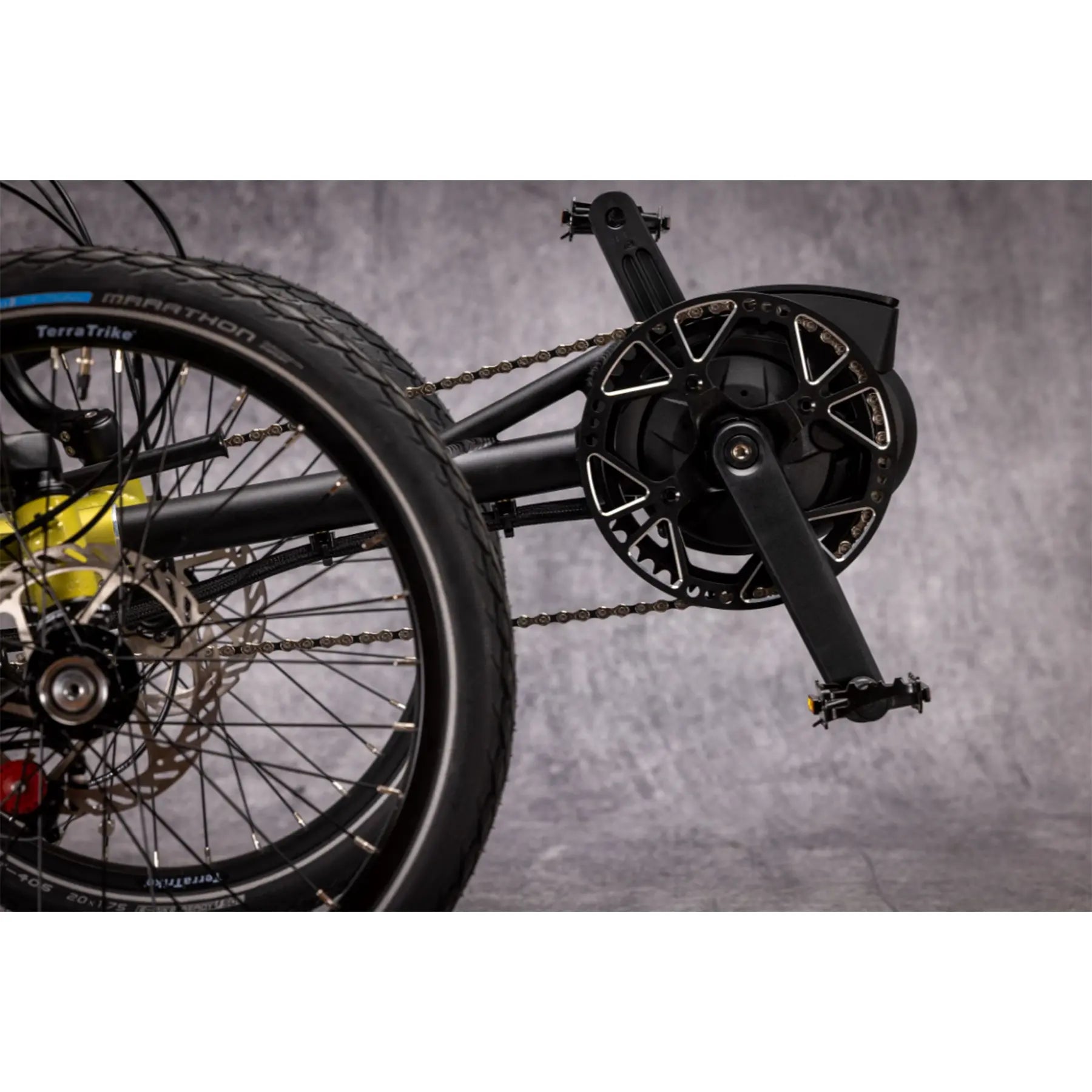 Closeup view of the Bosch motor on the TerraTrike E.V.O. Proton Green Recumbent Trike against a gray background.