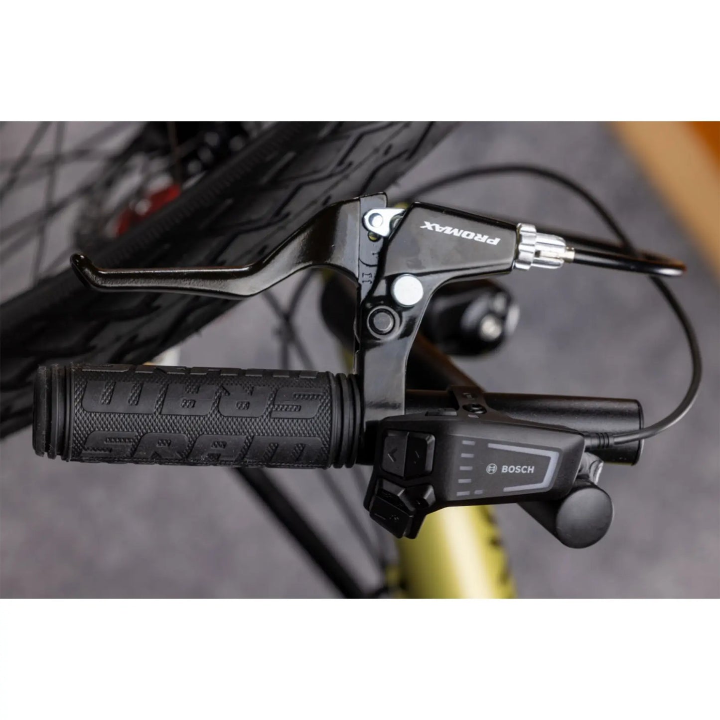 Closeup view of the Bosch controller on the TerraTrike E.V.O. Proton Green Recumbent Trike against a gray background.