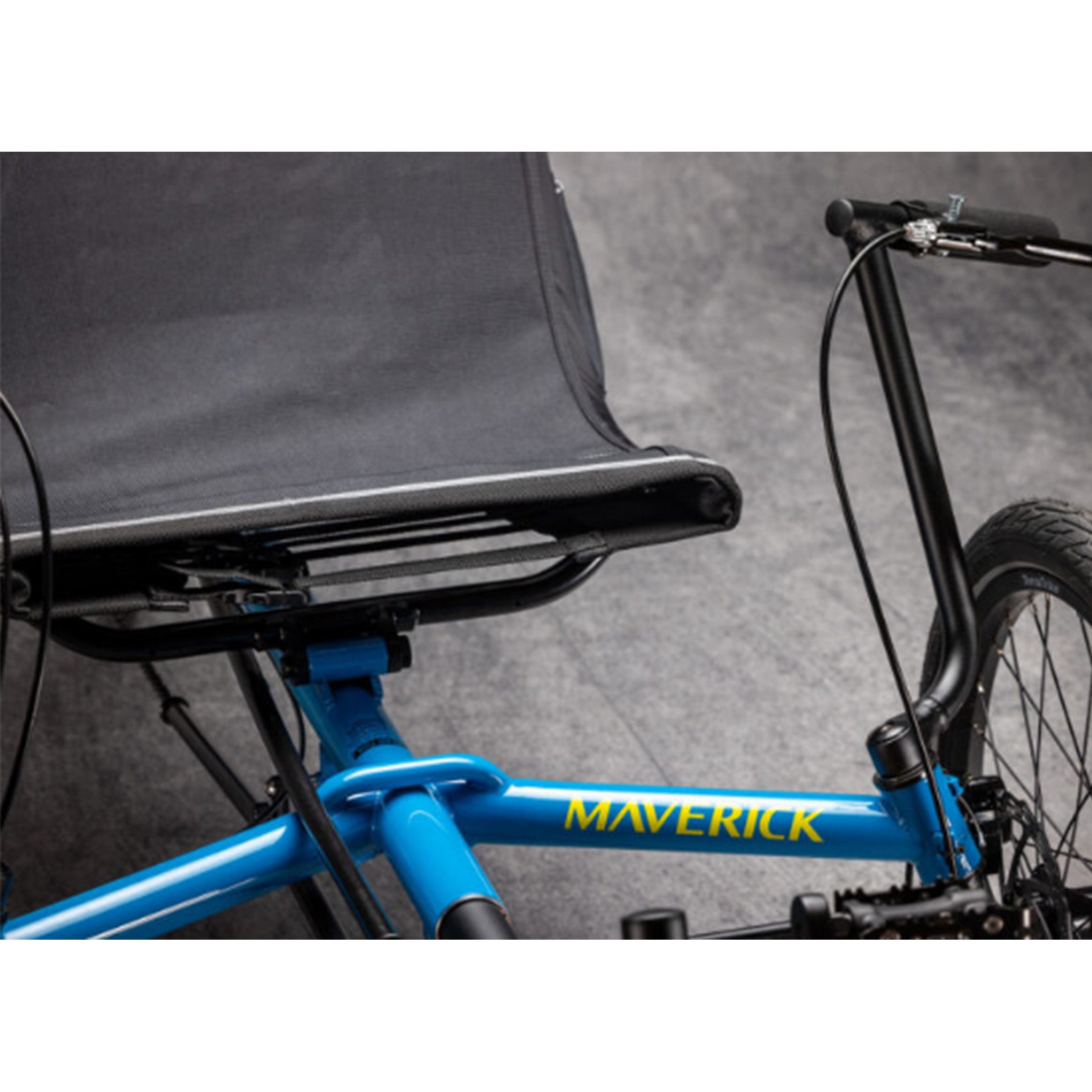 Closeup view of the frame and seat on the TerraTrike Maverick Eiffel Blue Recumbent Trike against a grey background.