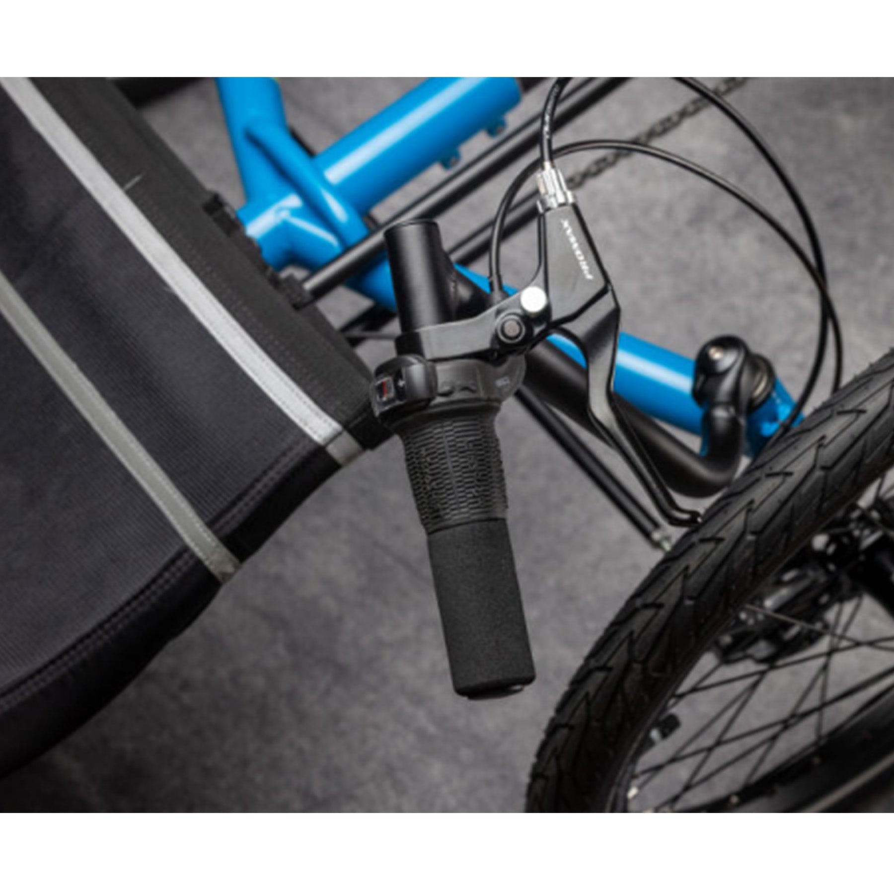 Closeup view of the handlebars on the TerraTrike Maverick Eiffel Blue Recumbent Trike against a grey  background.