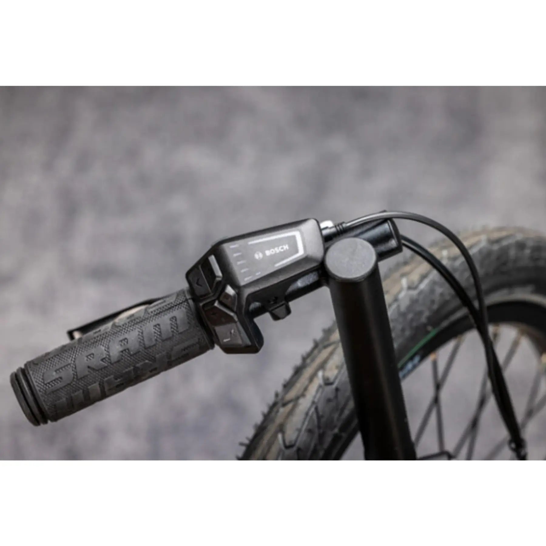 Close-up view of the Bosch Controller on the TerraTrike Rambler E-Plus Recumbent Trike in Gemstone against a grey background.