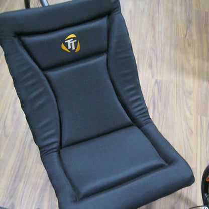 View of the black TerraTriike Seat Pad Cushion on a trike against wood background.