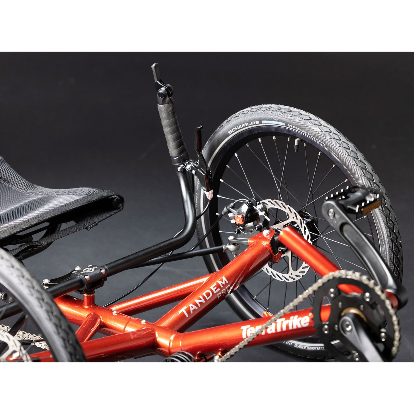 Closeup front view of the TerraTrike Tandem Pro Sparkle Copper Recumbent Trike against a grey background.