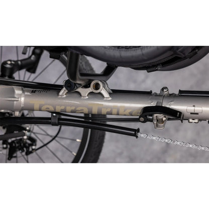 Closeup view of the seat adjustment and folding hinge on the TerraTrike Traveler Champagne Recumbent Trike against a gray background.