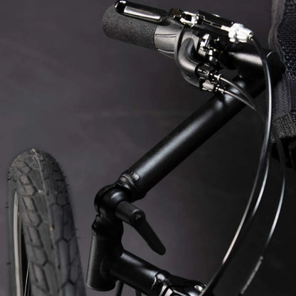 Closeup view of the handlebar, shifter and brake on the TerraTrike Traveler Champagne Recumbent Trike against a gray background.