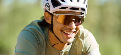 Person wearing a helmet and Tifosi Moab Lite sunglasses outdoors with a blurred natural background
