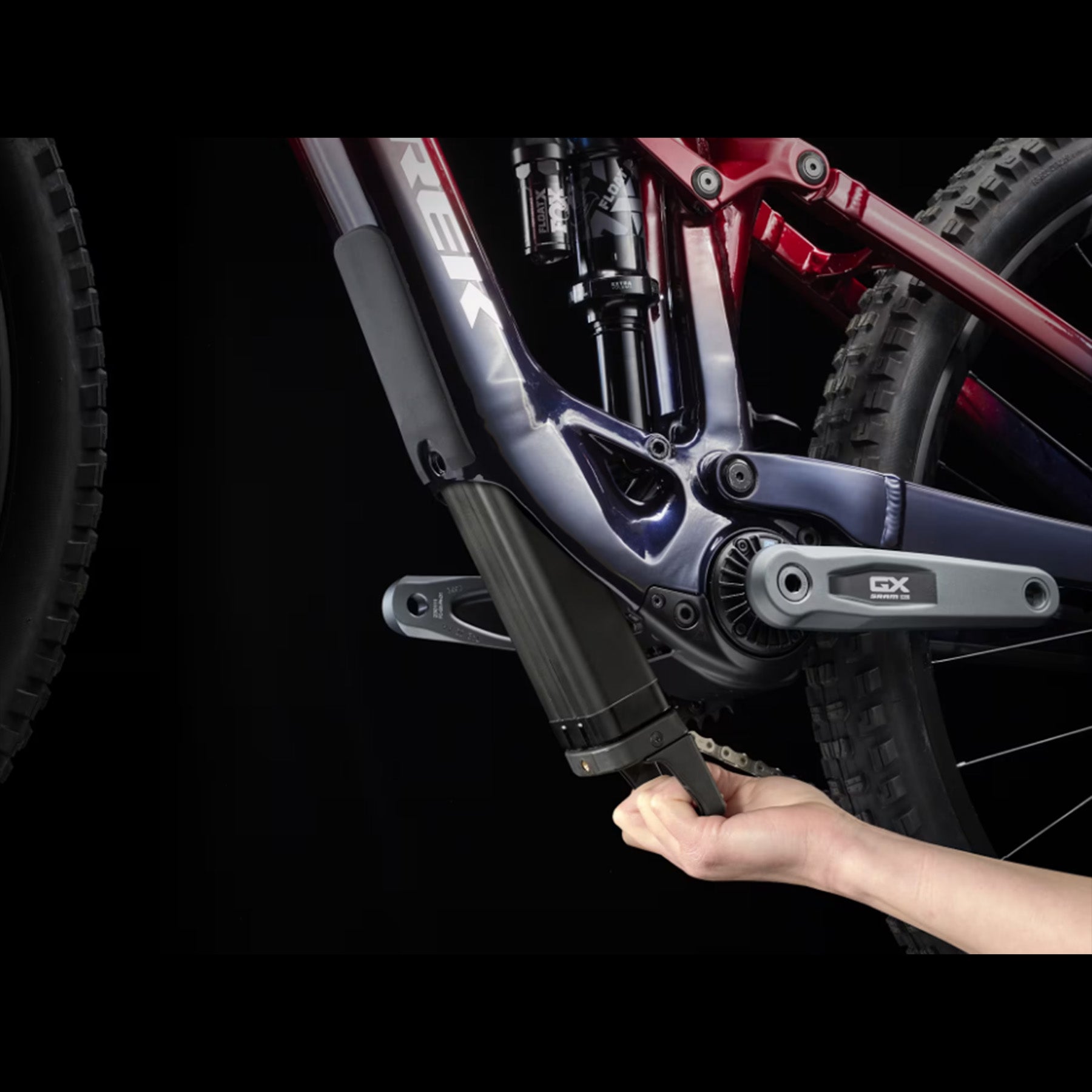 Closeup of the battery removal on a Trek Fuel Exe 8GX AXS mountain bike on a black background.