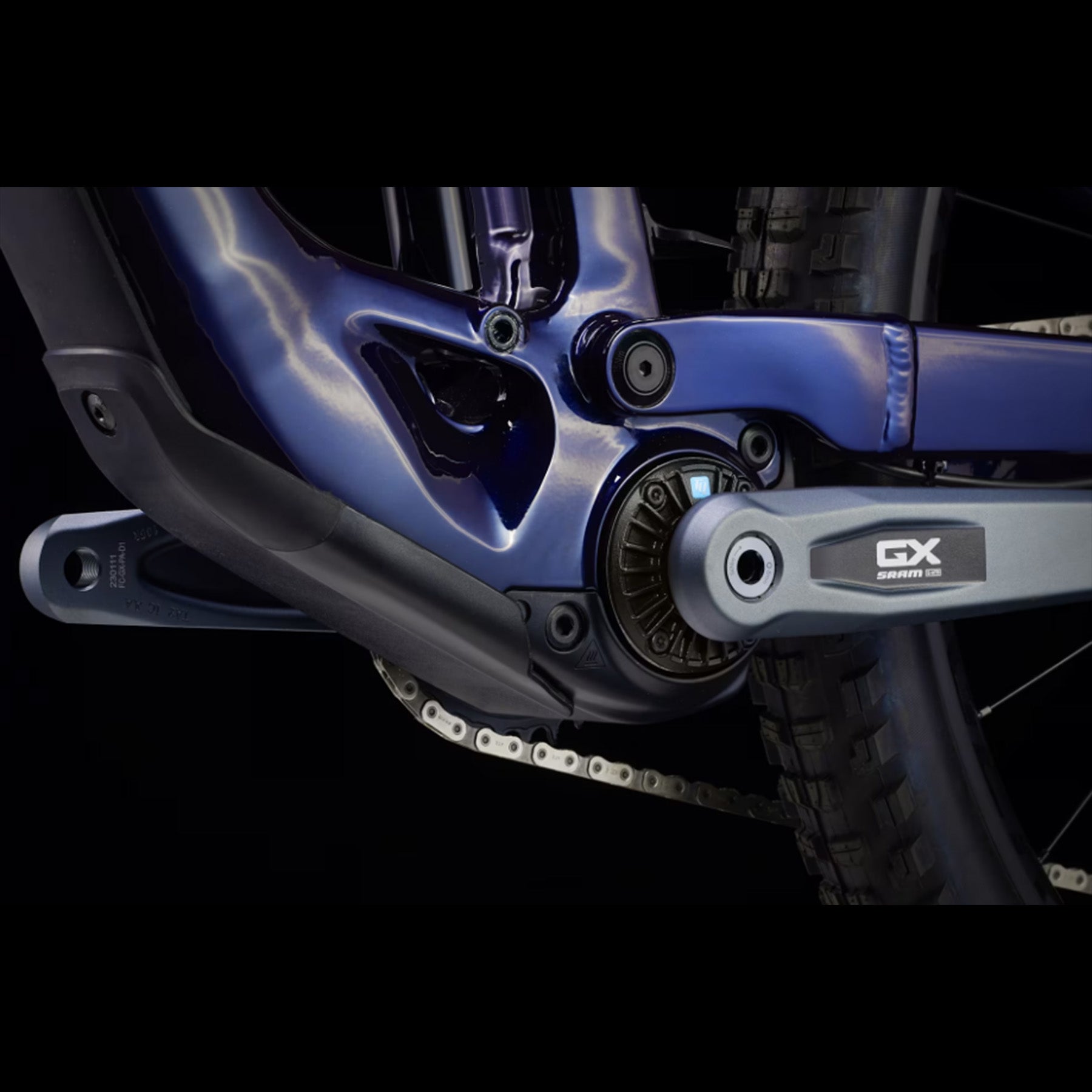 Closeup of the crank and bottom bracket on a Trek Fuel Exe 8GX AXS mountain bike on a black background.