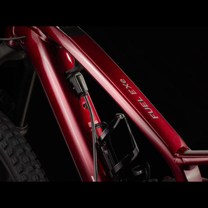 Closeup of the main frame on a Trek Fuel Exe 8GX AXS mountain bike on a black background.