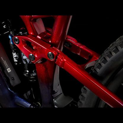 Closeup of the suspension on a Trek Fuel Exe 8GX AXS mountain bike on a black background.
