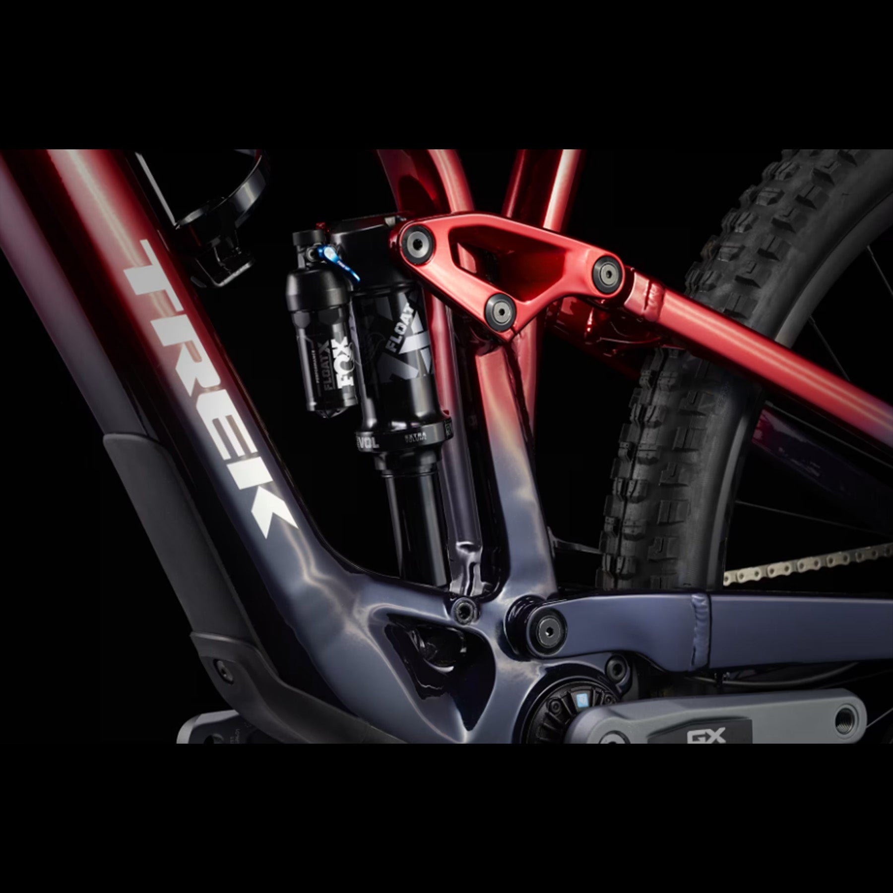 Closeup of the suspension on a Trek Fuel Exe 8GX AXS mountain bike on a black background.