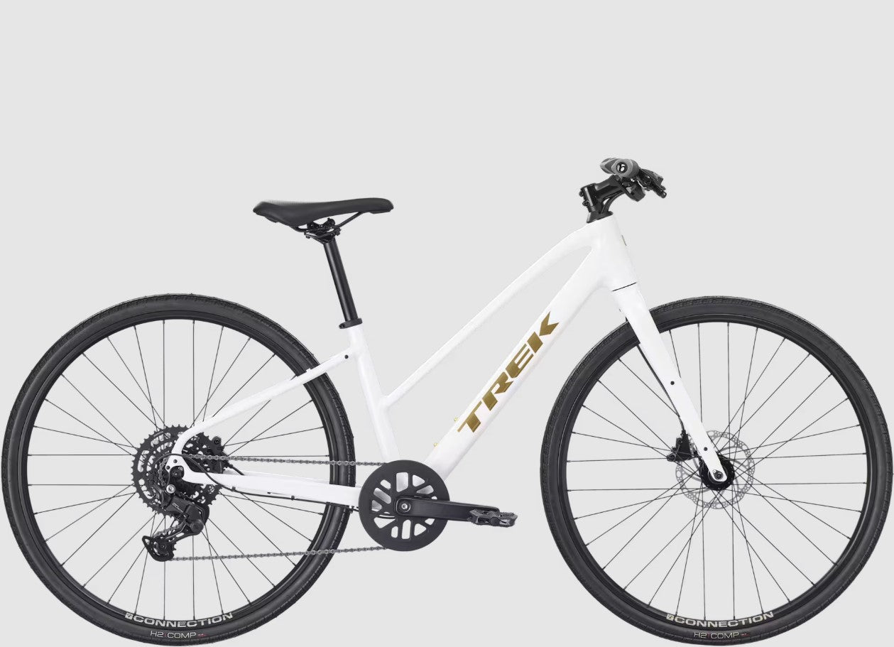 White Trek FX 2 bicycle with black components and gold 'Trek' branding on a light gray background.