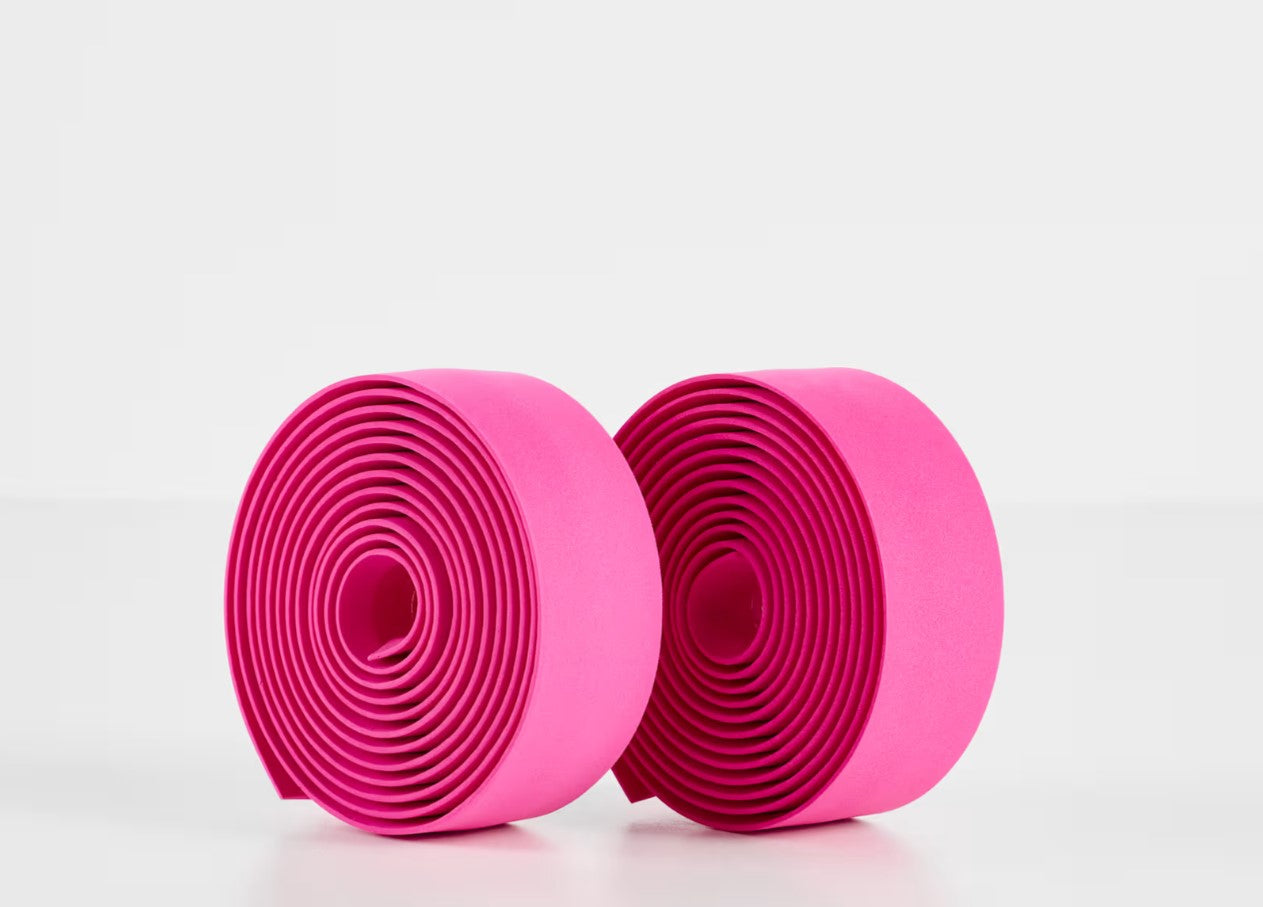 Two rolls of pink Trek gel cork bicycle handlebar tape on a white background.