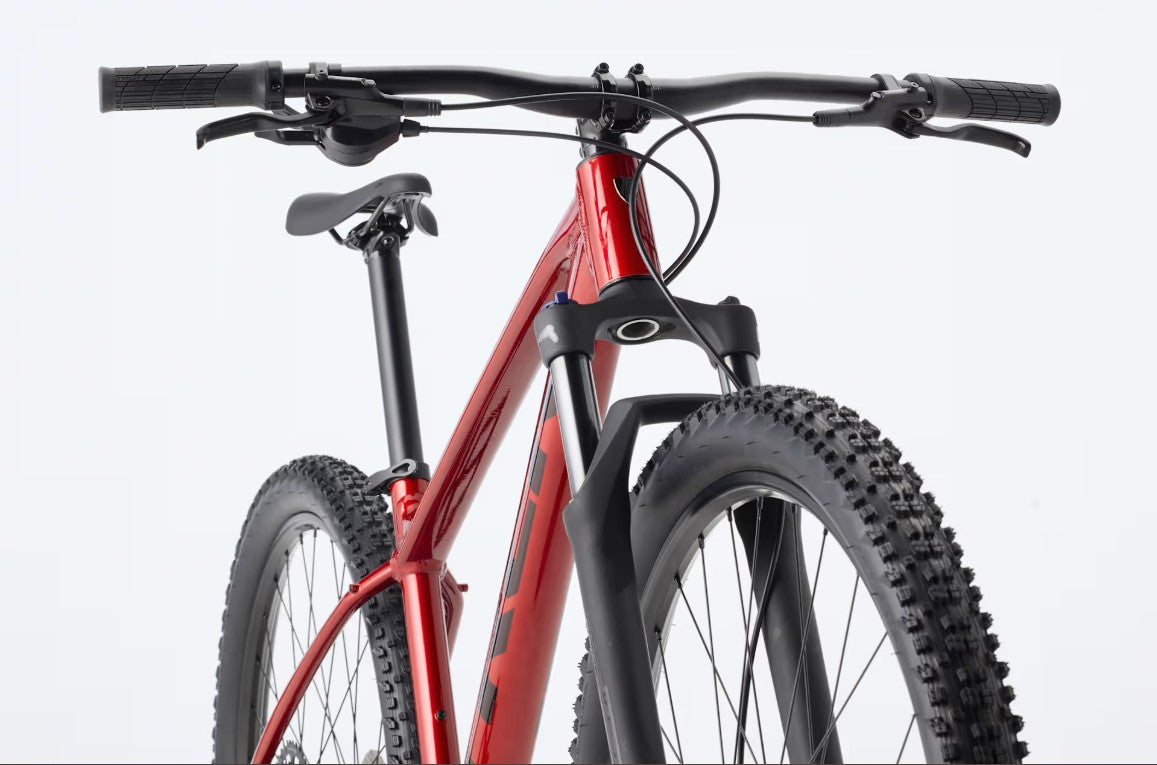 Front view of a red Trek Marlin 5 mountain bike with black components on a light gray background.