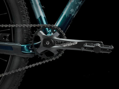 A closeup view of the crankset of the Trek Marlin 6 Gen 3 mountain bike in Miami Green to Dark Aquatic Fade against a black background.
