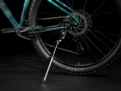 A closeup view of the kickstand of the Trek Marlin 6 Gen 3 mountain bike in Miami Green to Dark Aquatic Fade against a black background.