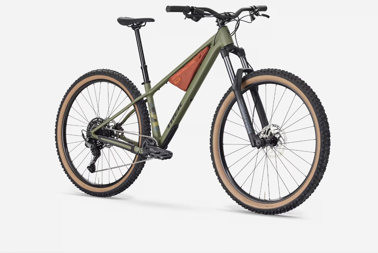 Right angled profile view of a matte olive Trek Roscoe 7 with tan-walled tires and brown frame bag on a white background. 